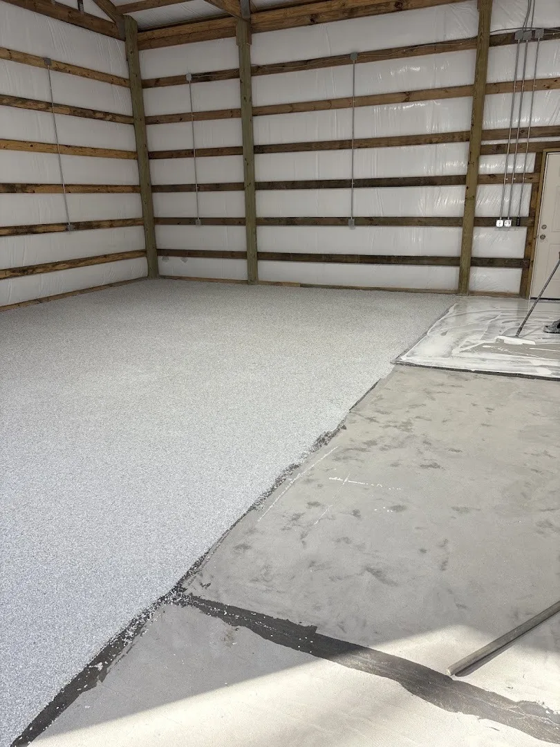 Light gray flake flooring inside a wood-framed building.