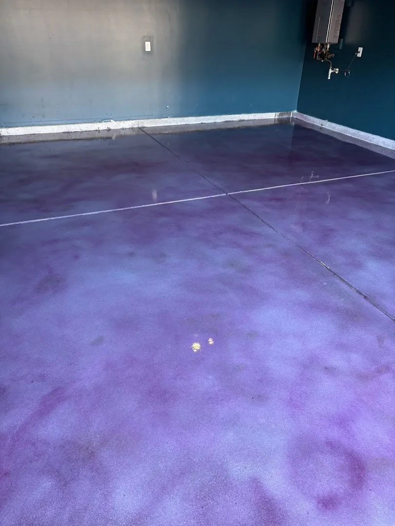 Purple metallic epoxy flooring beside a deep teal wall.
