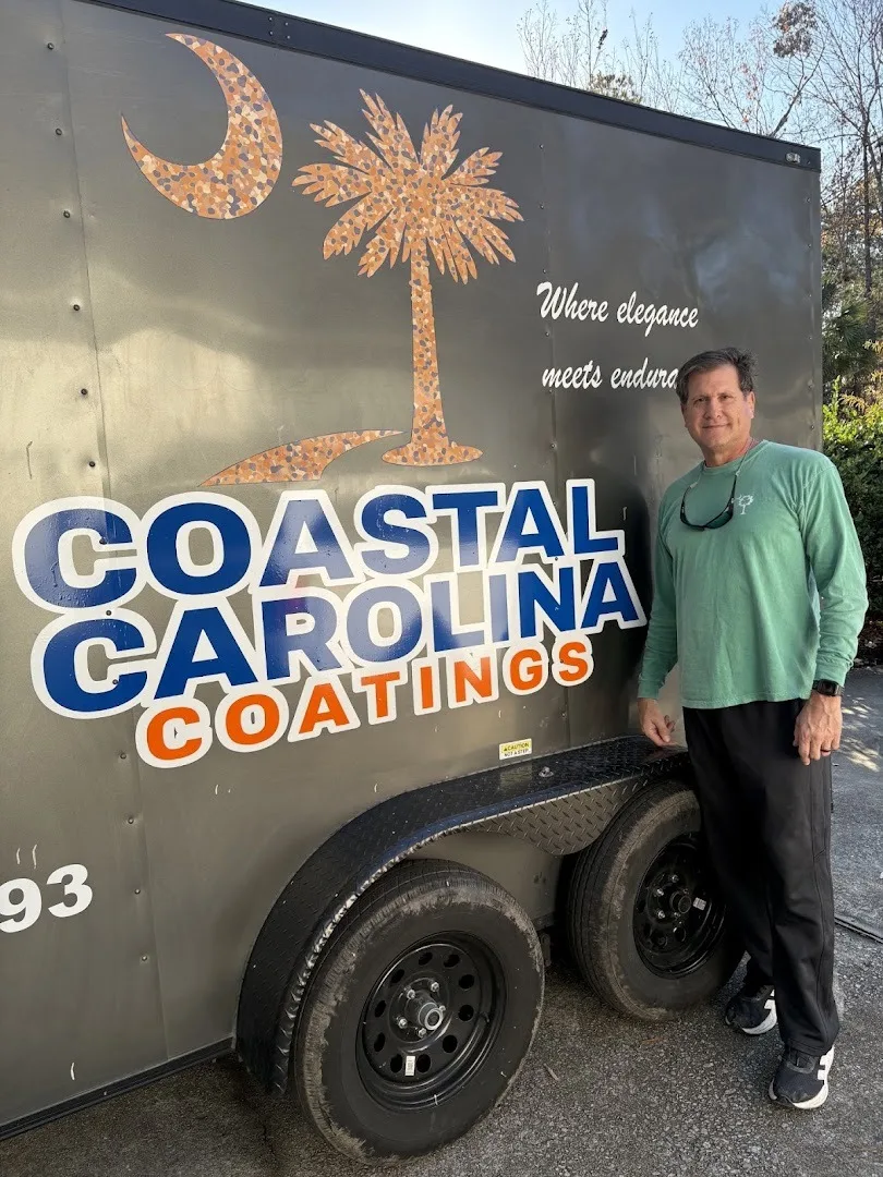Phil Smith standing beside his work trailer with the Coastal Carolina Coatings logo